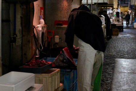 This man is cleaning what looks like a average size tuna head. Cleaning fish