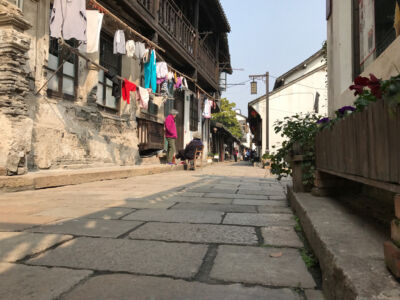 Daily life in the old town. Ladies chatting and knitting. Street in Xinchang town