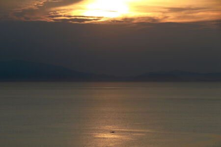 A fishing boat in bay at sunset