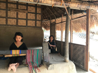 Little girls demonstrating how to make the textiles. Girls demo how to use a loom