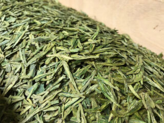 After some processing the tea leaves flatten and dry a bit. Processed Longjing tea leaves