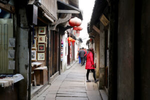 No scooters, just people and boats in the water town Narrow lane